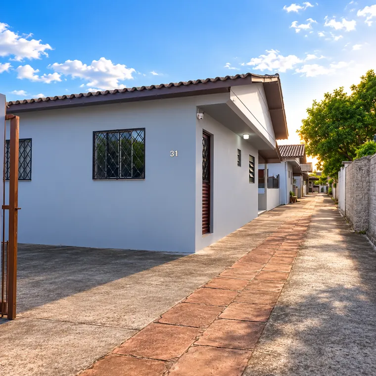 Fachada e corredor externo da casa no Bairro Fátima, em Canoas/RS
