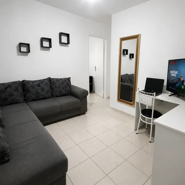 Sala de estar da casa com sofá de canto e televisão