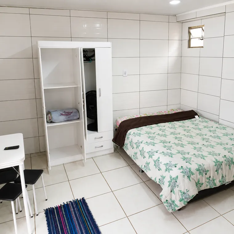 Quarto da kitnet em Cidreira com cama de casal e guarda-roupa