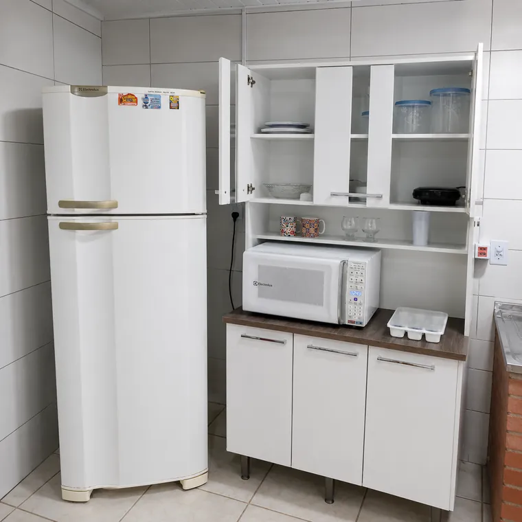 Cozinha da kitnet em Cidreira com geladeira, micro-ondas e armário